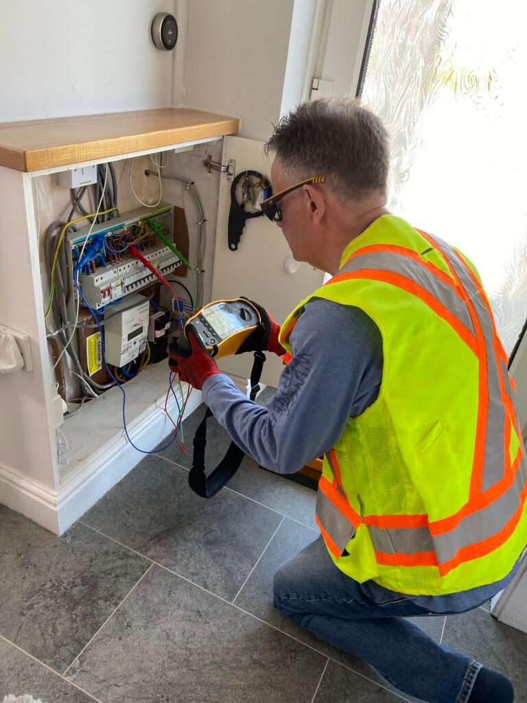 A certified home inspector examining & testing a residential electrical panel for a property inspection in Okotoks