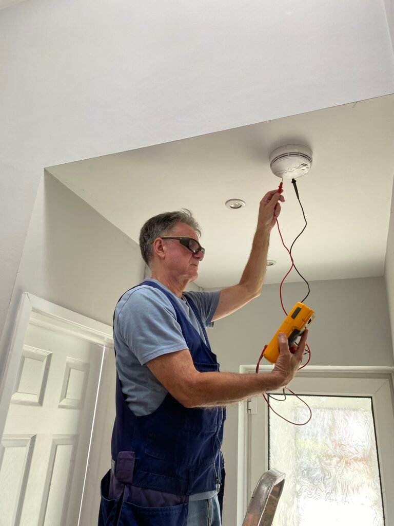 A certified home inspector testing smoke detectors for a property inspection